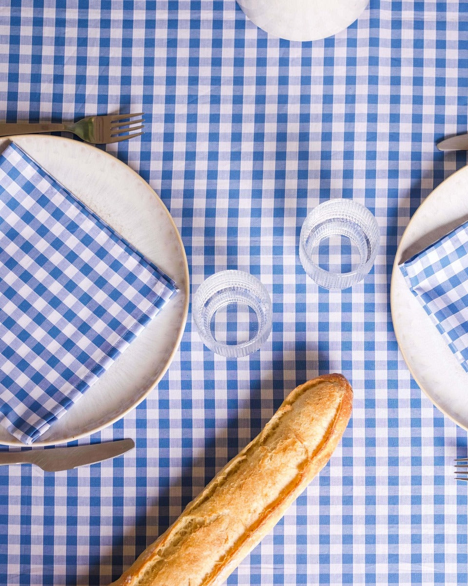 Lot de 2 serviettes de table en coton 100 %, à motif vichy bleu et blanc. Ce motif classique et raffiné apporte de la légèreté et de l’élégance à votre table, tout en mettant en valeur la douceur et la qualité du coton. Confectionnées artisanalement à Biarritz, elles sont idéales pour un repas chic et accueillant.