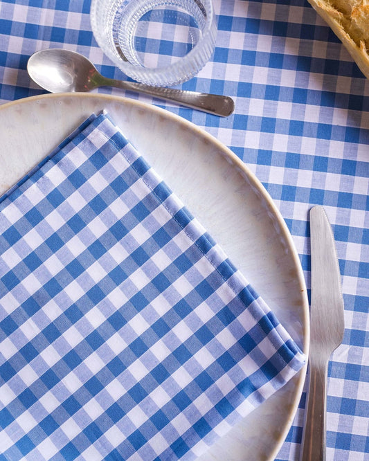 Lot de 2 serviettes de table en coton 100 %, à carreaux vichy bleu et blanc. Ce motif dynamique et élégant ajoutera une touche de fraîcheur et de sophistication à votre table, tout en offrant un confort incomparable. Fabriquées à la main à Biarritz, elles sont le détail parfait pour un repas raffiné.