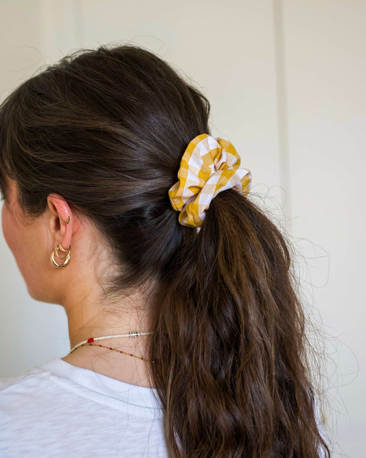 Chouchou en coton 100 %, à motif vichy jaune et blanc. Ce chouchou ajoute une touche joyeuse et colorée à votre coiffure, tout en offrant une texture douce et agréable. Confectionné à la main à Biarritz, il combine confort et style pour un accessoire à la fois pratique et élégant.