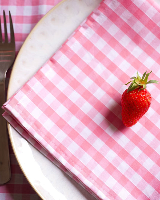 Lot de 2 serviettes de table en coton 100 %, à motif vichy rose et blanc. Ce design délicat et lumineux apporte une touche douce et élégante à votre table, tout en garantissant une douceur et une qualité exceptionnelles. Fabriquées à la main à Biarritz, elles sont le détail parfait pour un repas raffiné.